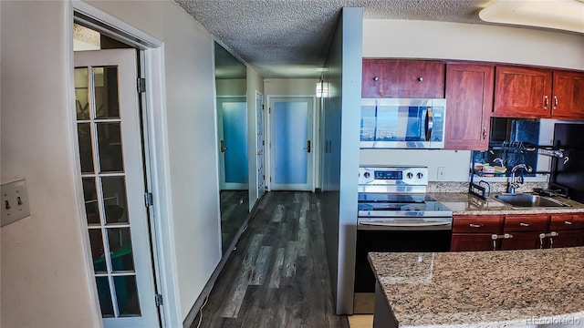 kitchen featuring sink, stainless steel appliances, dark hardwood / wood-style flooring, and a textured ceiling