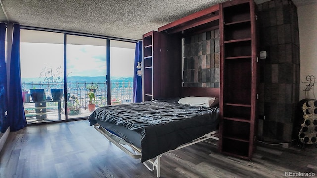 bedroom with dark hardwood / wood-style floors, access to outside, and a textured ceiling