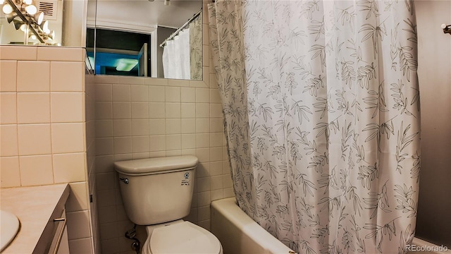 full bathroom featuring vanity, tile walls, toilet, and shower / tub combo