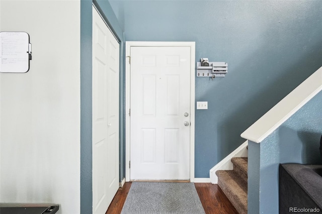 interior space with dark wood-type flooring, stairway, and baseboards