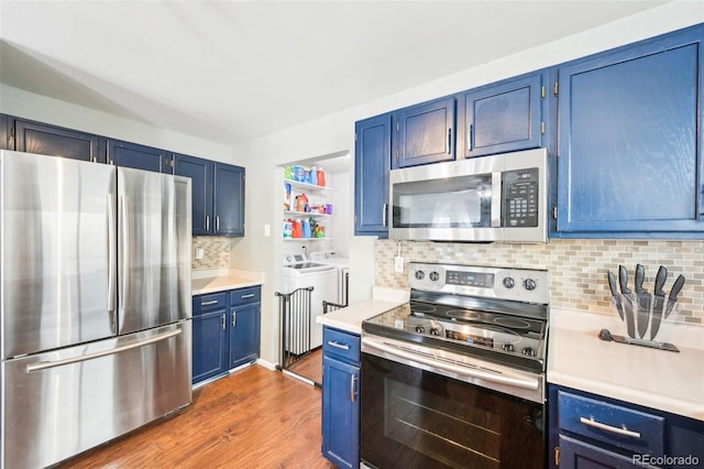 kitchen with blue cabinets, washer and clothes dryer, stainless steel appliances, and light countertops