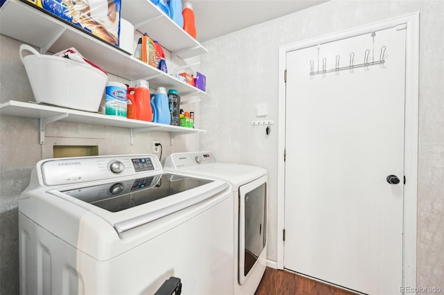 laundry area with dark wood-type flooring, washing machine and dryer, and laundry area