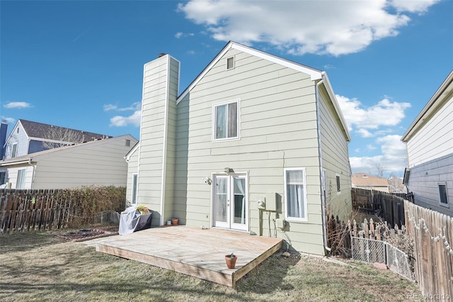 back of house featuring french doors, a fenced backyard, a chimney, and a wooden deck