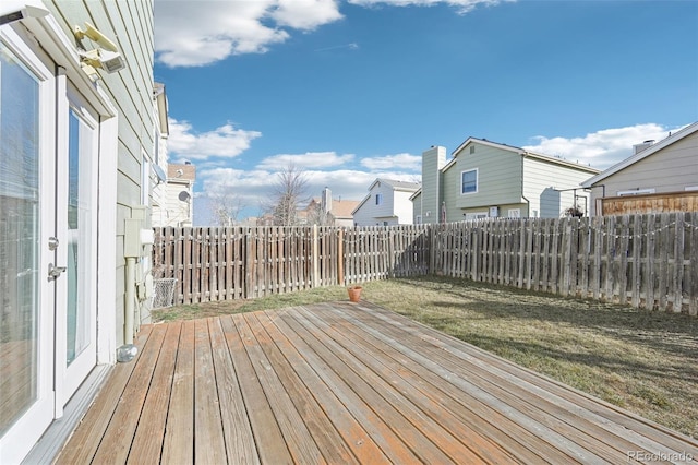 wooden terrace with a fenced backyard and a lawn