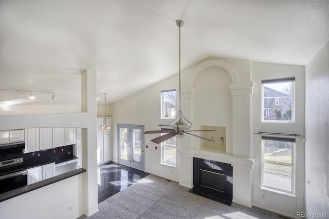 living area featuring high vaulted ceiling, baseboards, a tiled fireplace, and a ceiling fan