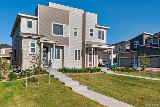 view of front of house with stone siding, a front lawn, a garage, and central AC