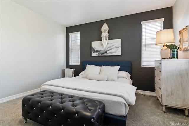 carpeted bedroom featuring baseboards and multiple windows