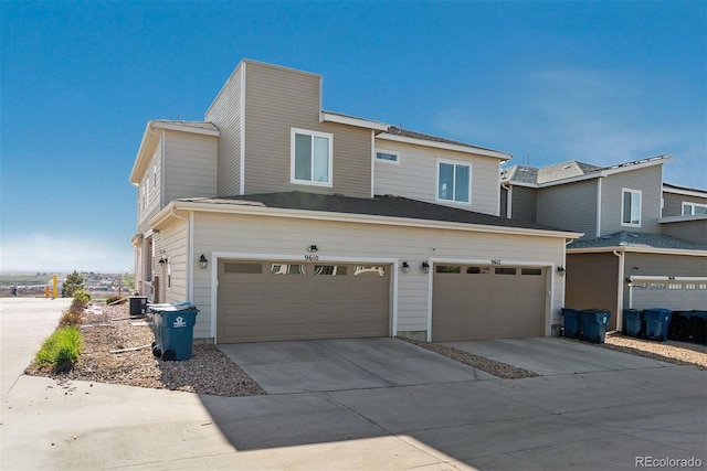 view of front facade with a garage, driveway, and cooling unit
