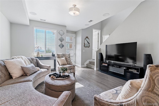 living room featuring wood finished floors, stairs, and baseboards