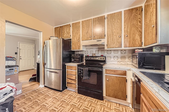 11816 Spring Dr, Northglenn, CO 80233 - kitchen with black appliances, under cabinet range hood, light countertops, backsplash, and parquet floors