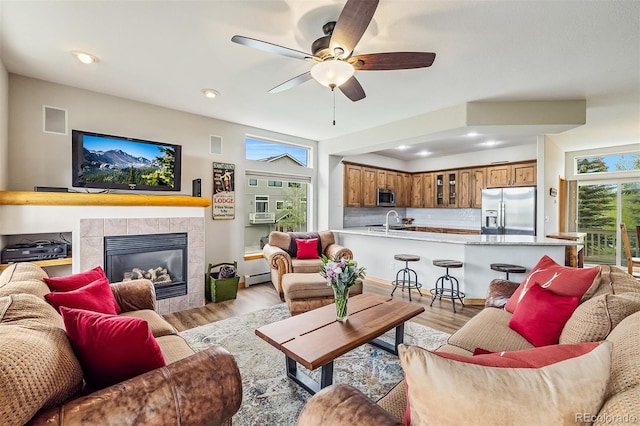 131 Creek Ln, Silverthorne, CO 80498 - living area with light wood-type flooring, ceiling fan, a fireplace, a baseboard radiator, and recessed lighting