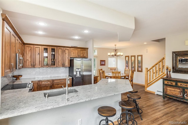 131 Creek Ln, Silverthorne, CO 80498 - kitchen featuring appliances with stainless steel finishes, brown cabinetry, a peninsula, dark wood-style flooring, and a chandelier