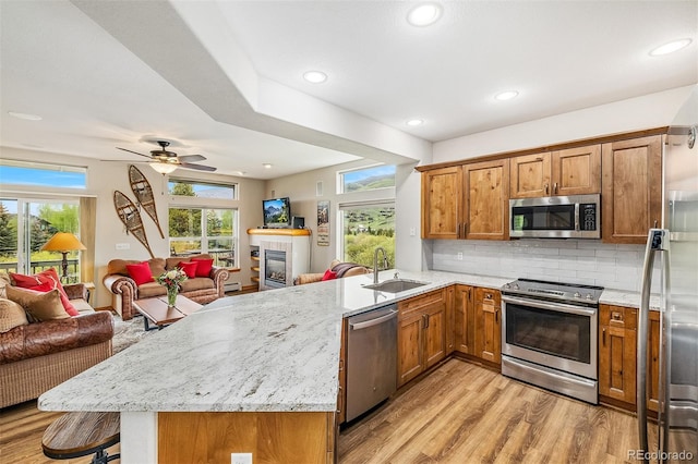 131 Creek Ln, Silverthorne, CO 80498 - kitchen with appliances with stainless steel finishes, open floor plan, a peninsula, brown cabinets, and recessed lighting