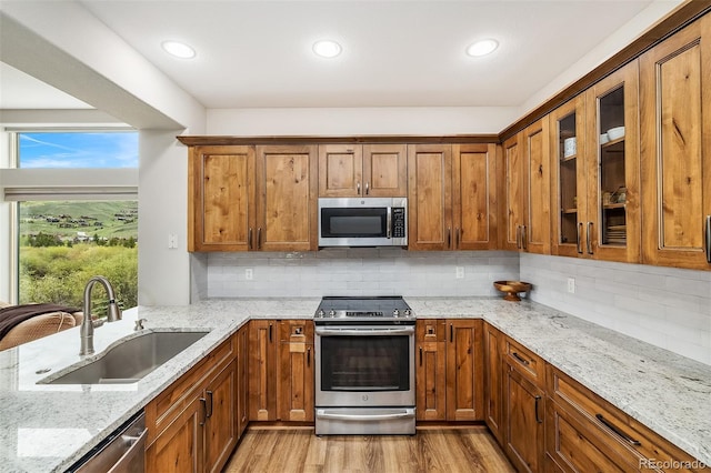 131 Creek Ln, Silverthorne, CO 80498 - kitchen with appliances with stainless steel finishes, brown cabinetry, light stone countertops, and recessed lighting