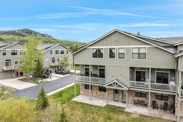 131 Creek Ln, Silverthorne, CO 80498 - rear view of house featuring board and batten siding, stone siding, a mountain view, and a balcony