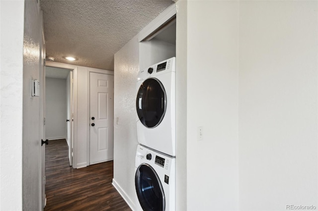 laundry room with a textured ceiling, stacked washer and dryer, and dark hardwood / wood-style floors