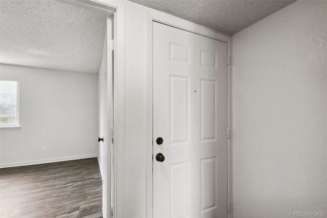 interior space with a textured ceiling and dark hardwood / wood-style flooring