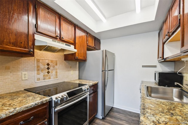 kitchen with sink, light stone counters, appliances with stainless steel finishes, tasteful backsplash, and dark hardwood / wood-style floors