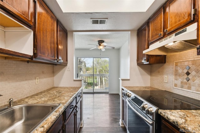 kitchen featuring a textured ceiling, stainless steel range with electric stovetop, dark hardwood / wood-style floors, and sink