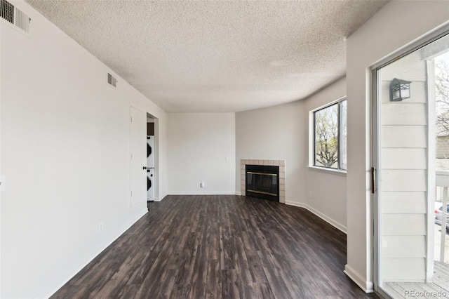 unfurnished living room with a fireplace, dark hardwood / wood-style floors, and a textured ceiling