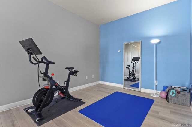 workout room featuring wood finished floors and baseboards