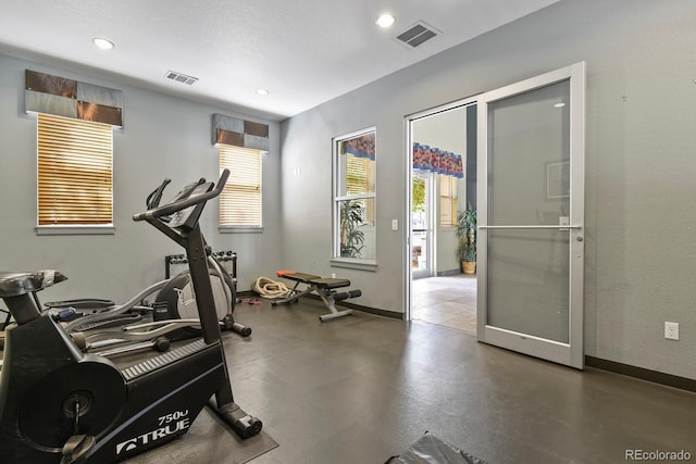 workout room featuring healthy amount of natural light, baseboards, and recessed lighting