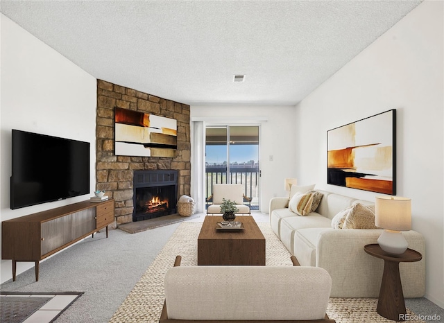 living area featuring carpet, a stone fireplace, and a textured ceiling