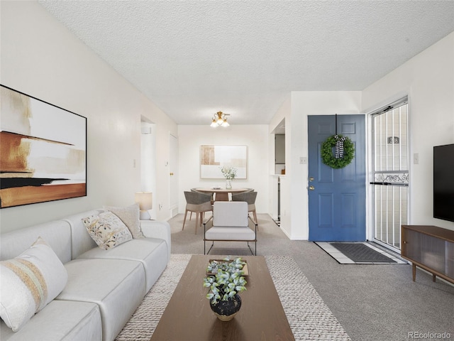 carpeted living room featuring baseboards and a textured ceiling