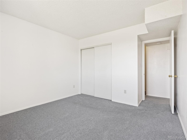 unfurnished bedroom featuring carpet floors, baseboards, and a closet