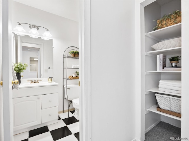 bathroom featuring toilet, vanity, tile patterned floors, and baseboards