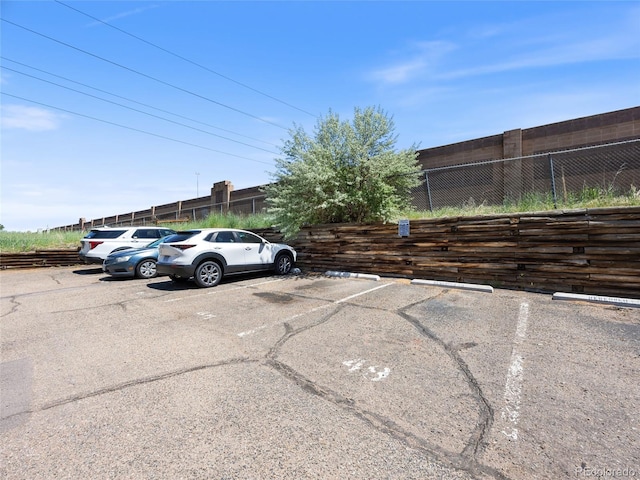 uncovered parking lot featuring fence