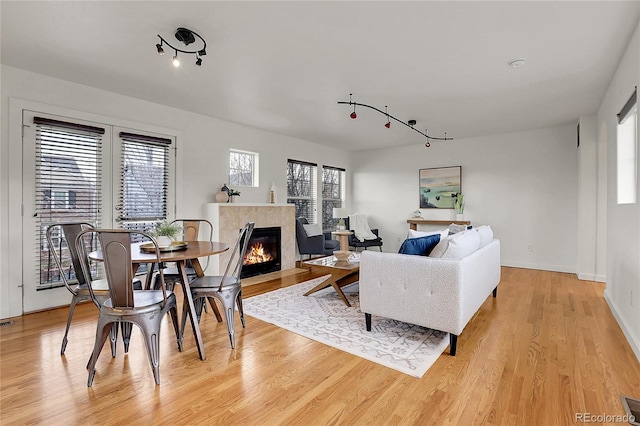 living room with a tile fireplace and light hardwood / wood-style floors