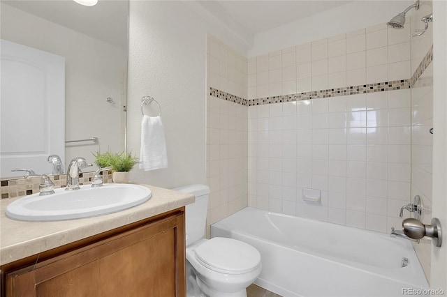 full bathroom with tiled shower / bath, vanity, and toilet