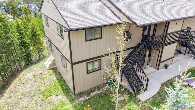 144 Tall Pine Cir, Grand Lake, CO 80447 - view of side of property with stairs, roof with shingles, a patio area, and a deck