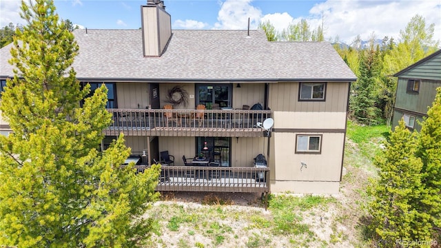 144 Tall Pine Cir, Grand Lake, CO 80447 - rear view of house with a shingled roof, a chimney, and a wooden deck