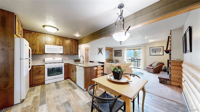 144 Tall Pine Cir, Grand Lake, CO 80447 - kitchen with white appliances, open floor plan, a peninsula, light wood-style flooring, and a sink