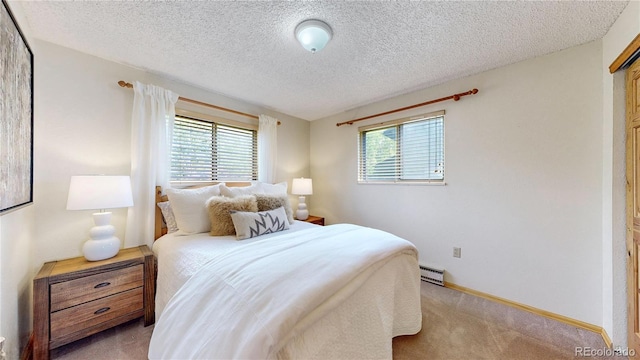 144 Tall Pine Cir, Grand Lake, CO 80447 - bedroom with a baseboard heating unit, multiple windows, carpet, a textured ceiling, and baseboards