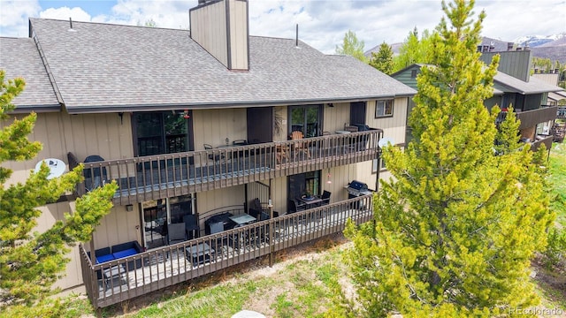 144 Tall Pine Cir, Grand Lake, CO 80447 - back of house with a shingled roof, a chimney, and a wooden deck