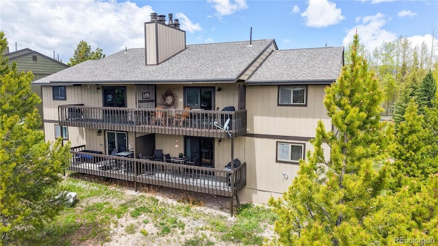 144 Tall Pine Cir, Grand Lake, CO 80447 - rear view of house featuring a chimney, a shingled roof, and a balcony