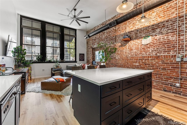 kitchen with a center island, brick wall, light hardwood / wood-style flooring, and ceiling fan