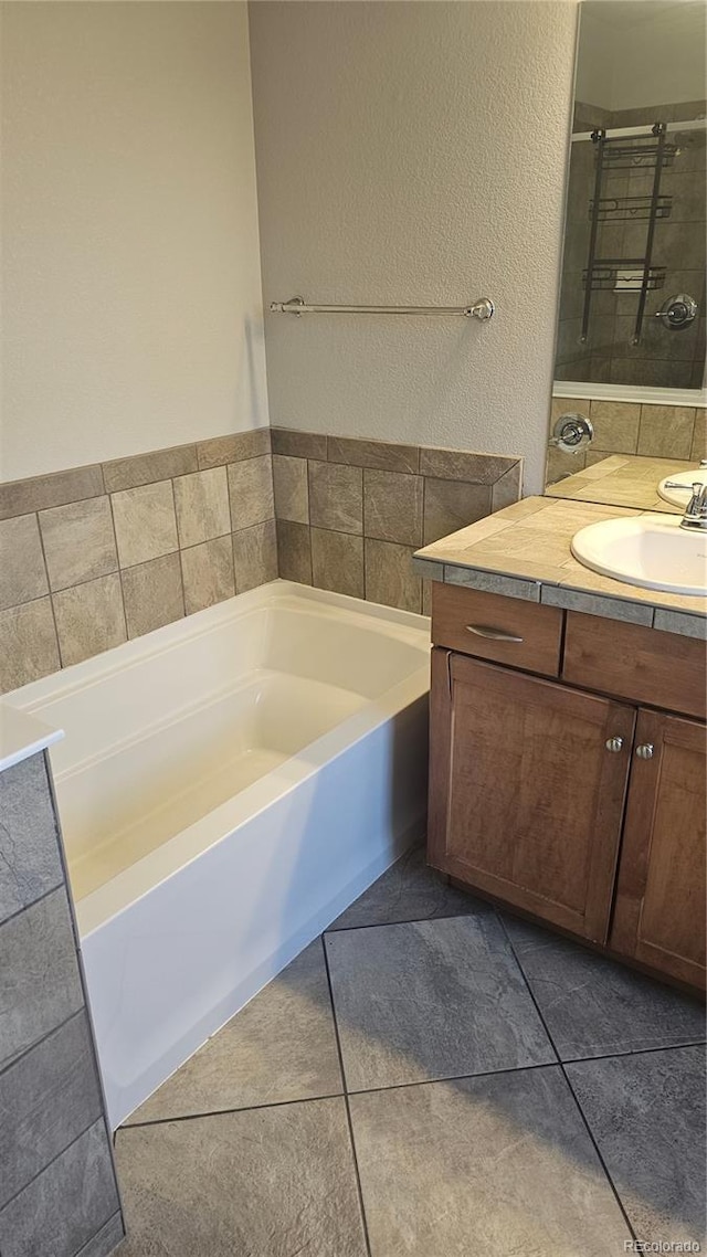 bathroom featuring vanity, tile patterned flooring, and a washtub