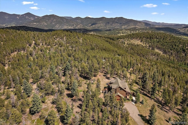 drone / aerial view featuring a forest view and a mountain view