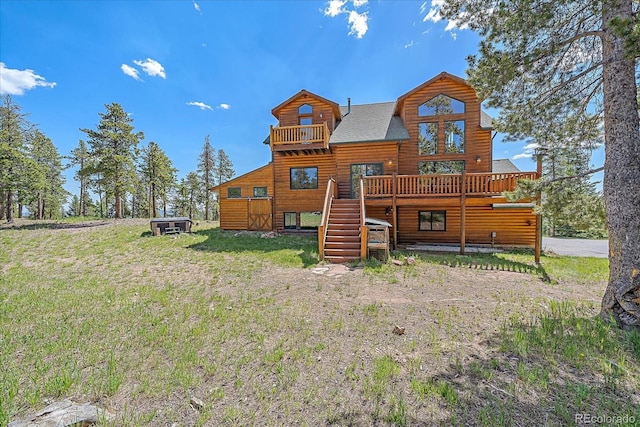 back of property with a deck, a yard, stairway, and faux log siding