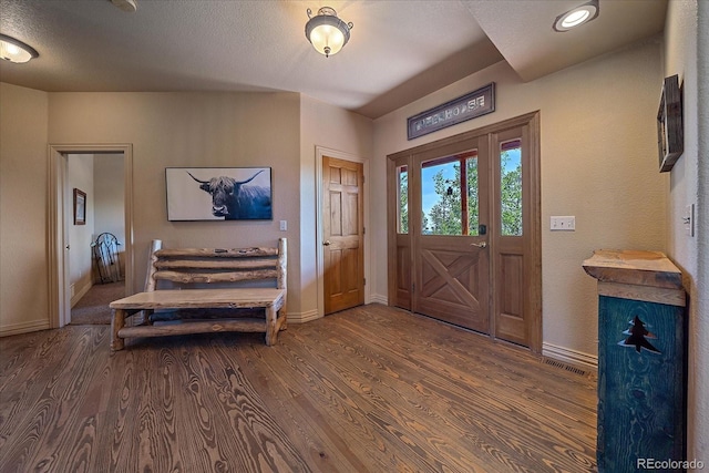 entrance foyer with dark wood-type flooring and a textured ceiling