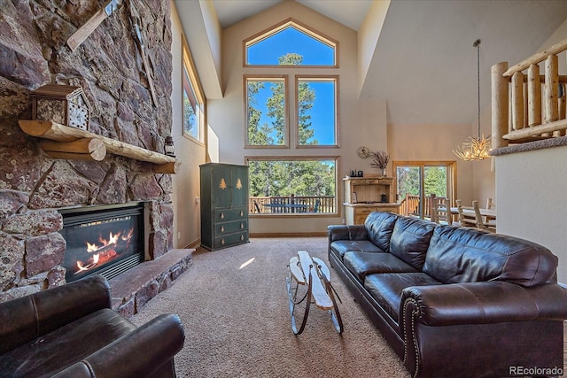 living area with high vaulted ceiling, a fireplace, baseboards, carpet, and an inviting chandelier