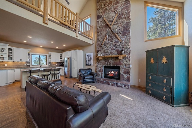 living room with a fireplace and high vaulted ceiling