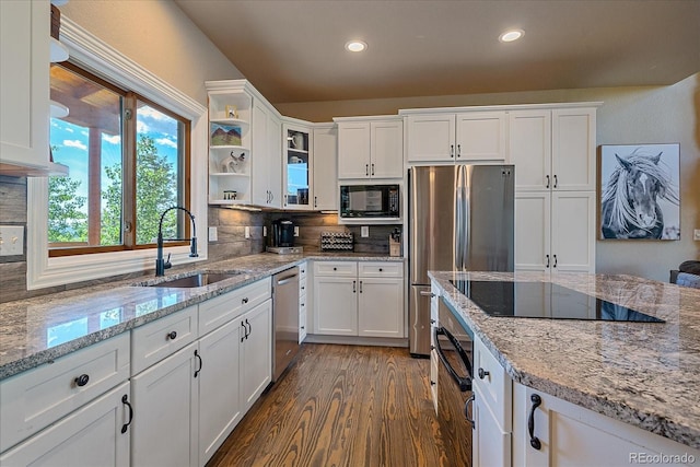 kitchen featuring decorative backsplash, white cabinets, and black appliances