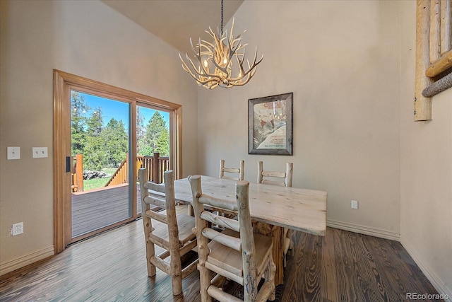 dining space with a chandelier, hardwood / wood-style floors, and high vaulted ceiling