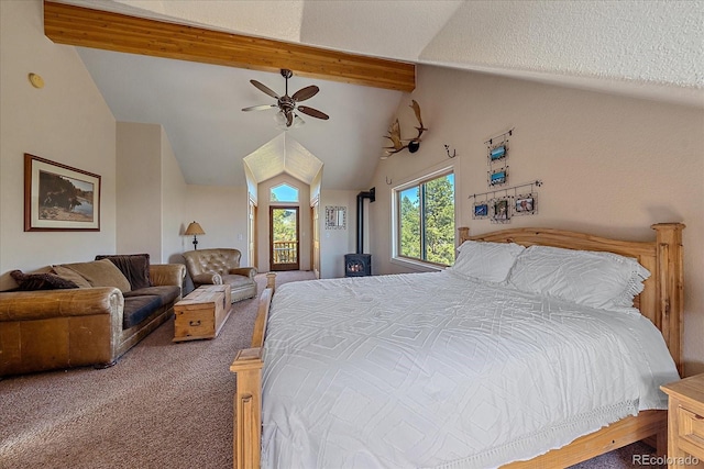 carpeted bedroom featuring a wood stove, ceiling fan, and lofted ceiling with beams