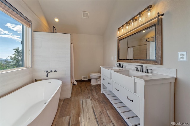 full bathroom featuring hardwood / wood-style floors, lofted ceiling, vanity, independent shower and bath, and tile walls